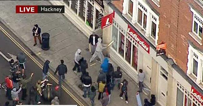 rioter smashes shop window